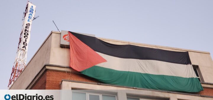 Activistas exhiben una bandera palestina y una pancarta frente a la embajada de Israel en Madrid